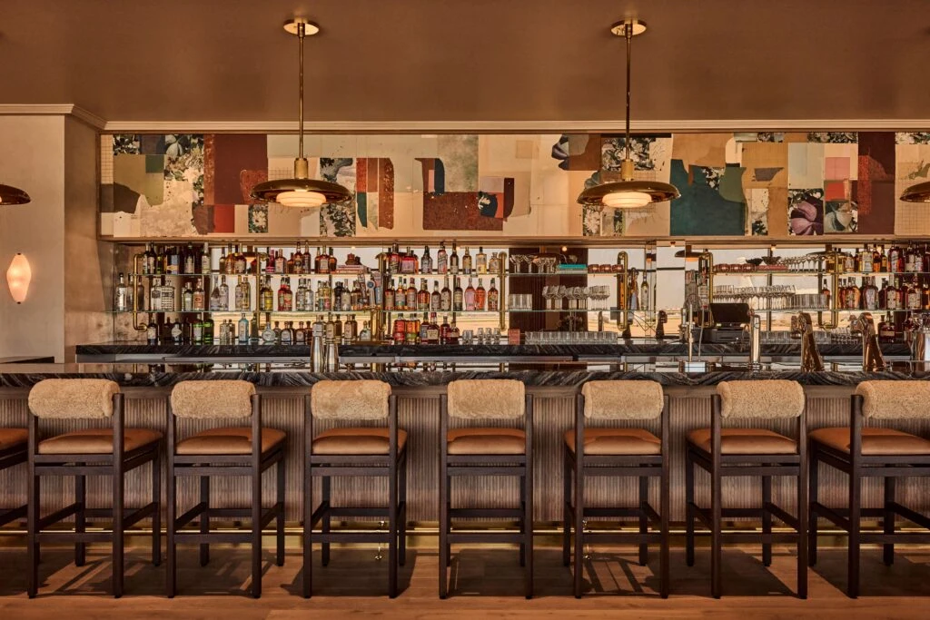 Warm plaster wall finishes surrounding the Salon bar at PS DFW Airport